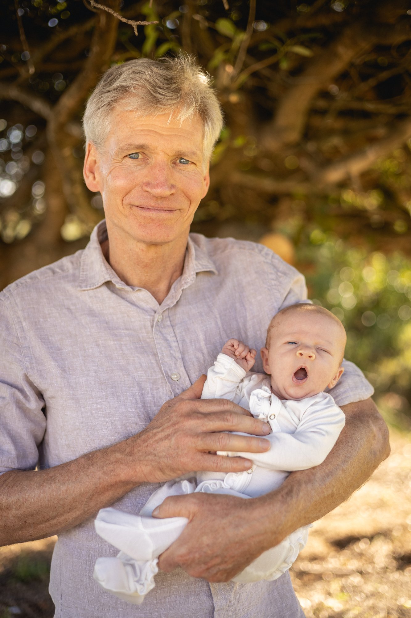 Dr Charles S Nienaber holding a newborn baby